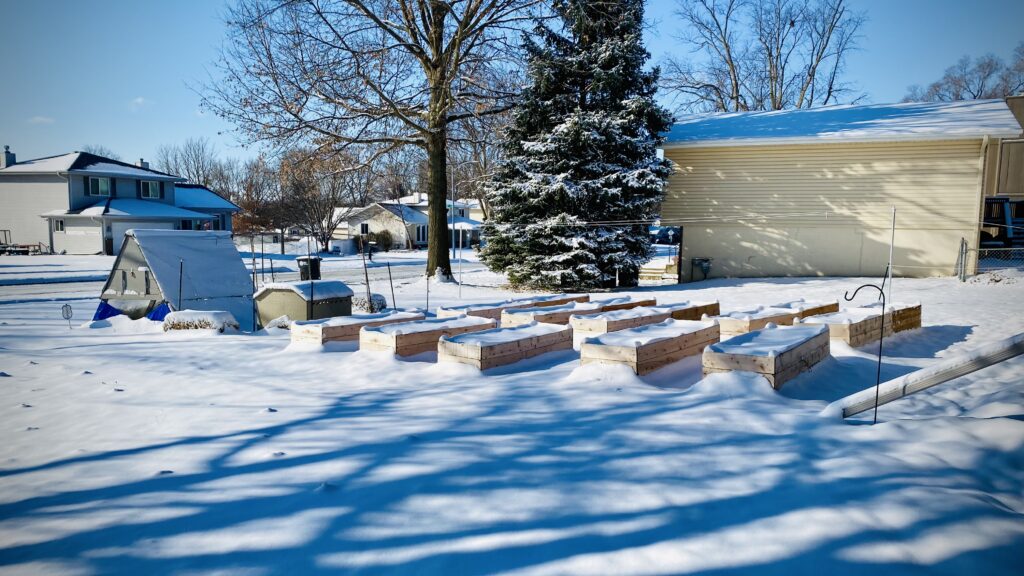 snow on raised garden bed in lawn